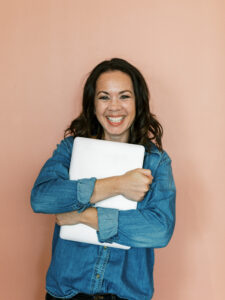 Photo of Tayler from Enji - digital marketing for small businesses - holding her laptop
